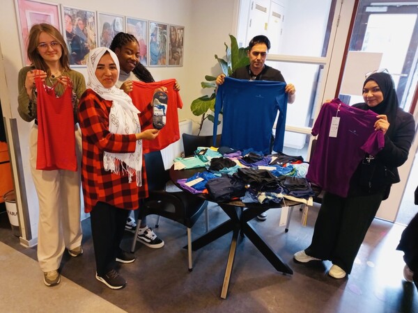 Vrijwilligers van Piëzo zijn druk bezig met het uitpakken en sorteren van de door Rademaker Sports gedoneerde sportkleding foto Stichting Piëzo